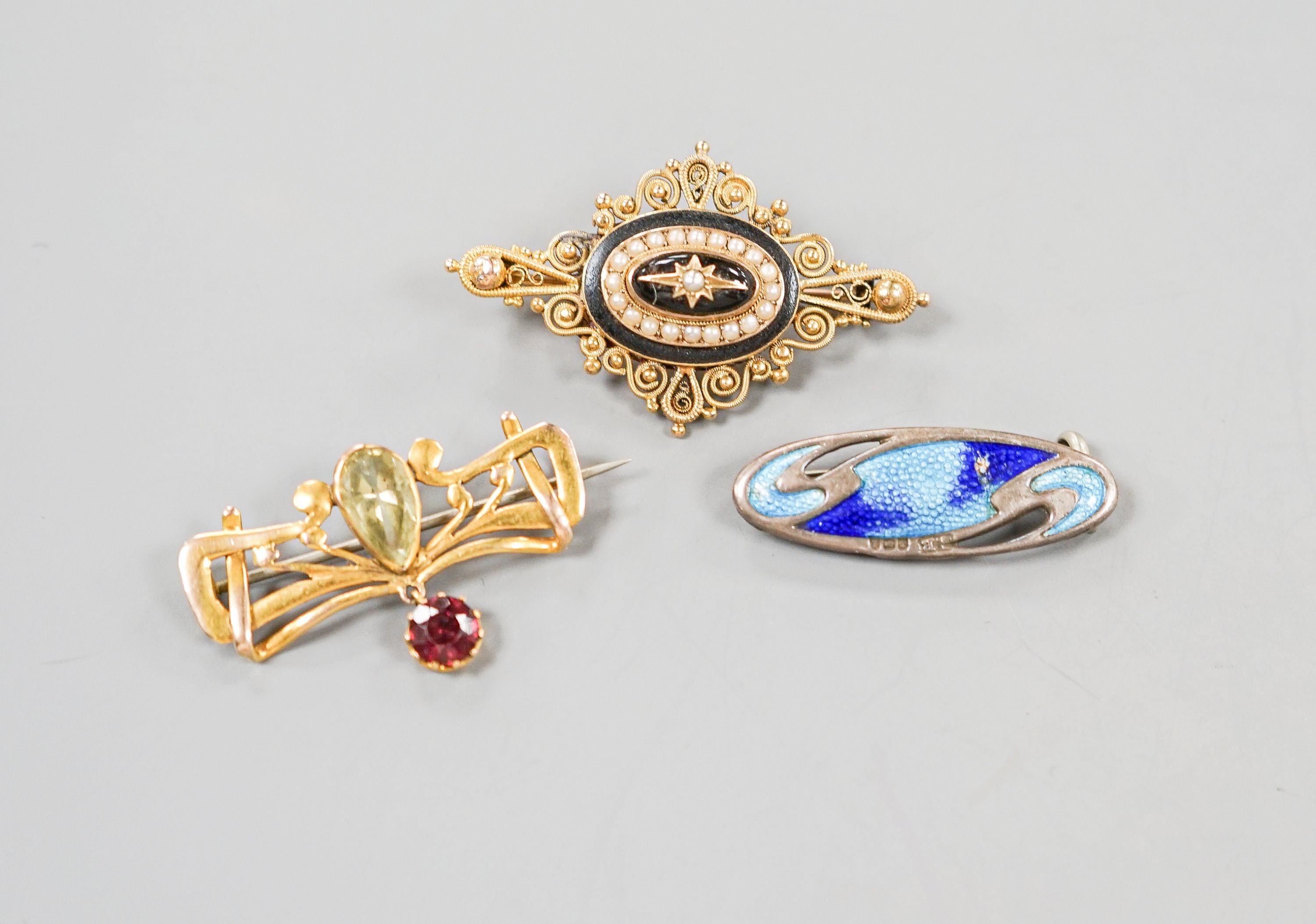A Victorian yellow metal, black enamel and split pearl set quatrefoil brooch, 43mm, one other yellow metal and gem set drop brooch and a George V silver and enamel set brooch.